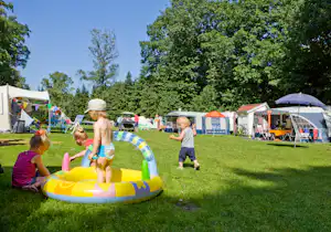 Spielende Kinder im Gras vor dem Zeltplatz auf dem Campingplatz Aan Veluwe
