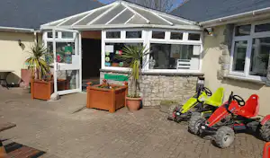 Acorn Camping and Caravan Site - Eingang zum Gebäude der Rezeption mit zwei davor stehenden Kettcars