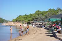 Ada Camping  - Strand vom Campingplatz mit Sonnenschirmen und Liegestühlen am Mittelmeer