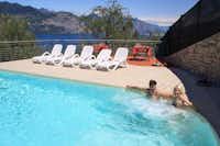 Agricampeggio Paradiso  -  Camper im Pool vom Campingplatz mit Liegestühlen in der Sonne