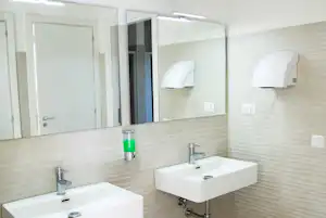 Zwei Waschbecken im modernen Camping-Badezimmer mit Spiegeln, Wandfliesen und Holzfußboden.