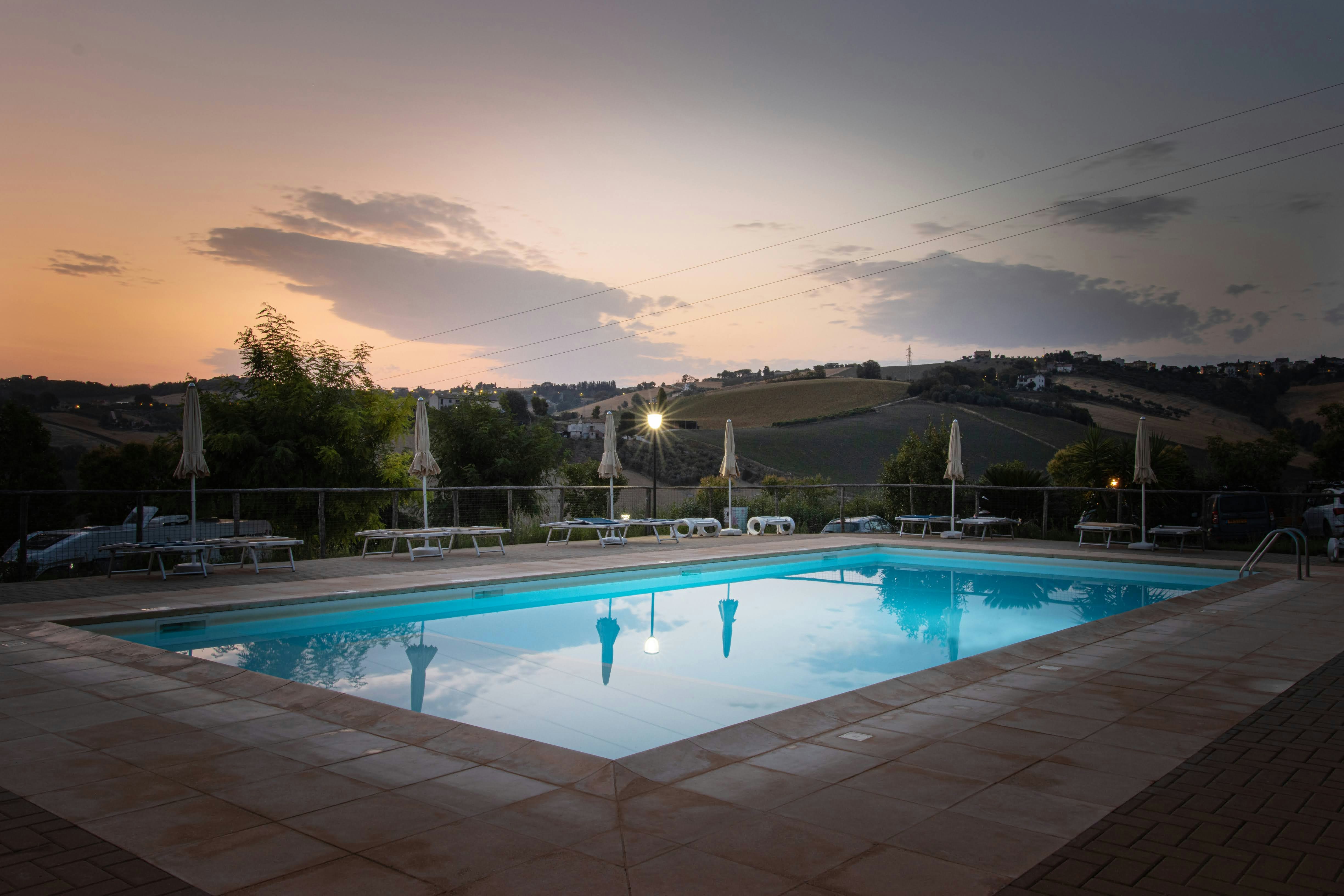Agricamping Tramonto Rosso - Pool mit Sonnenliegen bei Sonnenuntergang