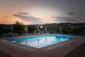 Agricamping Tramonto Rosso - Pool mit Sonnenliegen bei Sonnenuntergang