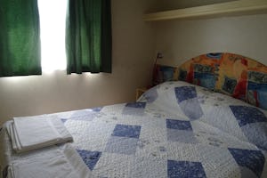 Agriturismo Cascina Le Volpi - Doppelbett im Schlafzimmer eines Mobilheims