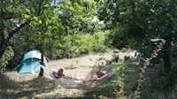 Aire Naturelle de Camping Les Cerisiers - Gäste beim Entspannen in einer Hängematte auf ihrem Stellplatz