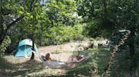 Aire Naturelle de Camping Les Cerisiers - Gäste beim Entspannen in einer Hängematte auf ihrem Stellplatz