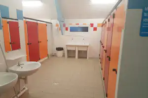 Airotel Camping Le Walric - Innenraum des Sanitärgebäudes mit Waschbecken und Toilettenkabinen