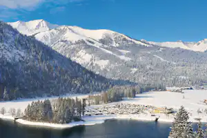 Alpen-Caravanpark Achensee- Schneebedeckte Wohnwagen in winterlicher Berglandschaft