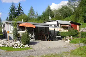 Alpencamp Marienberg - Camper sitzen unter der Markise ihres Wohnwagens