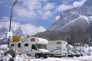 Alpencamp Marienberg - Wohnmobile auf Stellplätzen im Winter mit den Bergen der Alpen im Hintergrund