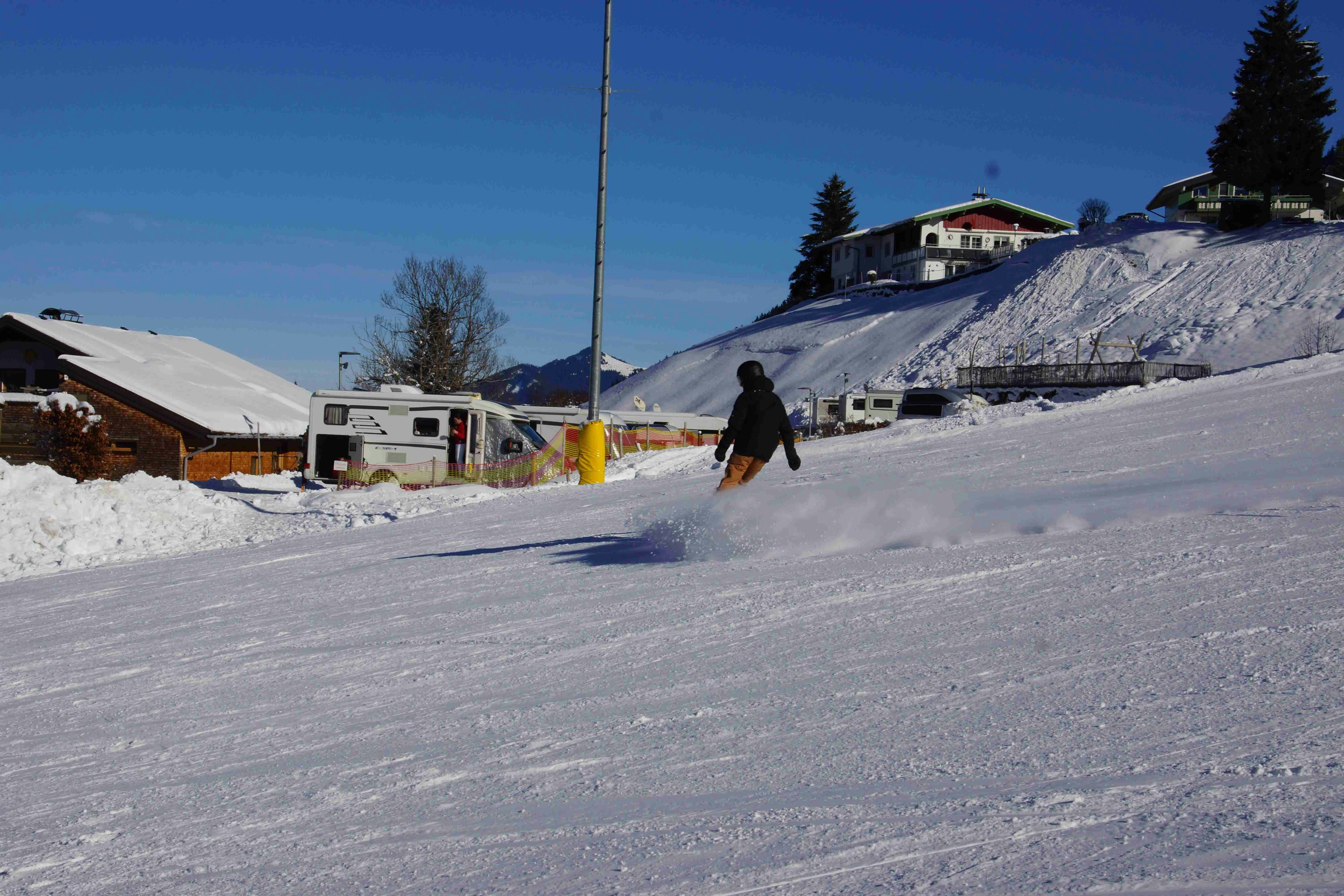 Alpencamping Haller  - Camper beim Snowboarden auf dem Campingplatz