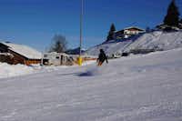 Alpencamping Haller  - Camper beim Snowboarden auf dem Campingplatz