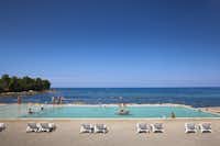 Aminess Maravea Camping Resort  -  Poolbereich vom Campingplatz mit Liegestühlen in der Sonne und mit Blick auf das Mittelmeer