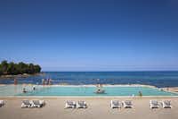 Aminess Maravea Camping Resort  -  Poolbereich vom Campingplatz mit Liegestühlen in der Sonne und mit Blick auf das Mittelmeer