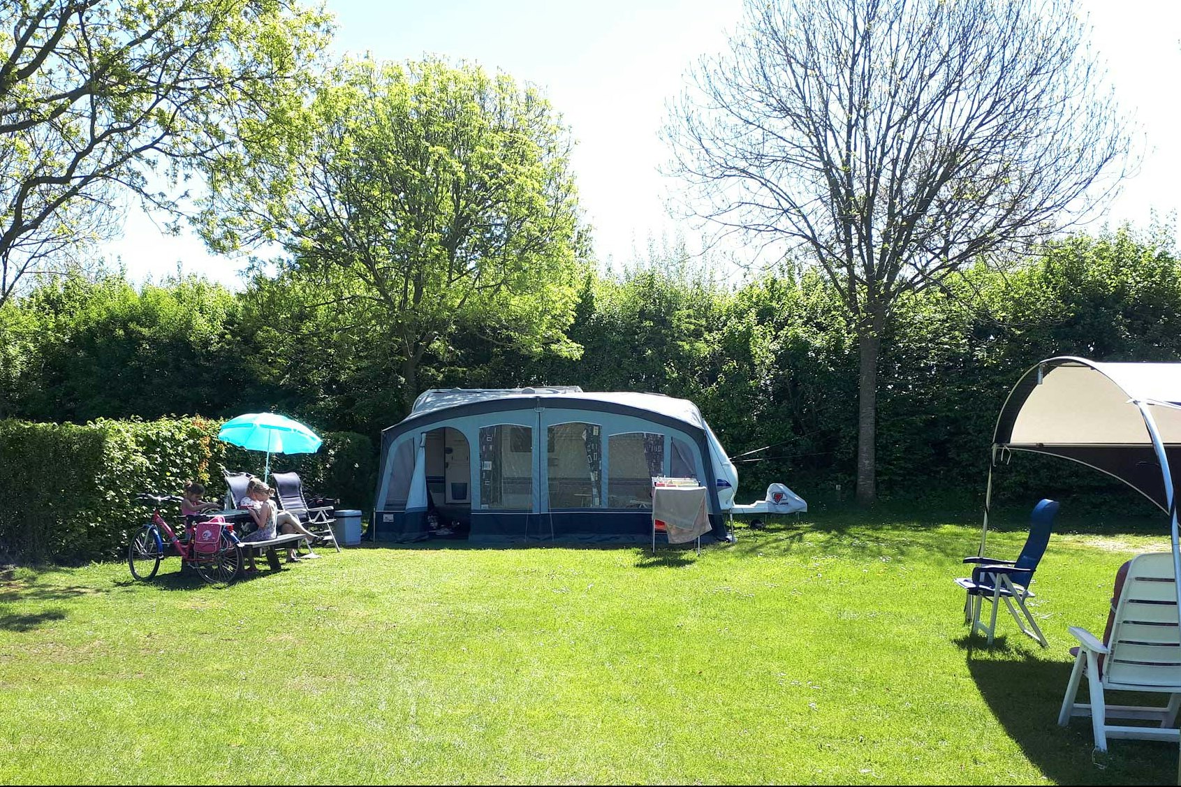 Molecaten Park Wijde Blick  -  Wohnwagen auf dem Stellplatz vom Campingplatz auf grüner Wiese