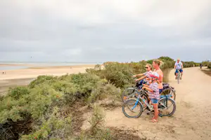 Ardoer Camping De Zwinhoeve - Camper mit Fahrrädern am Strand vom Campingplatz an der Nordsee