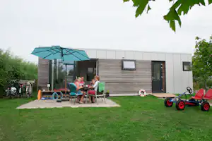 Ardoer Camping Duinoord aan Zee - Camper Familie auf der Veranda vom Mobilheim auf dem Campingplatz