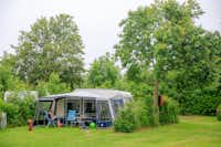 Ardoer Camping Ginsterveld - Campingzelt auf dem Campingplatz vor dem eine Frau die Sonne genießt