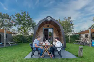 Ardoer Camping Ginsterveld - Familie beim Frühstücken auf der Terrasse ihrer Mietunterkunft