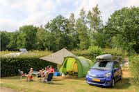 Ardoer Comfortcamping De Bosgraaf  - Camper Familie am Zelt auf dem Stellplatz vom Campingplatz auf grüner Wiese