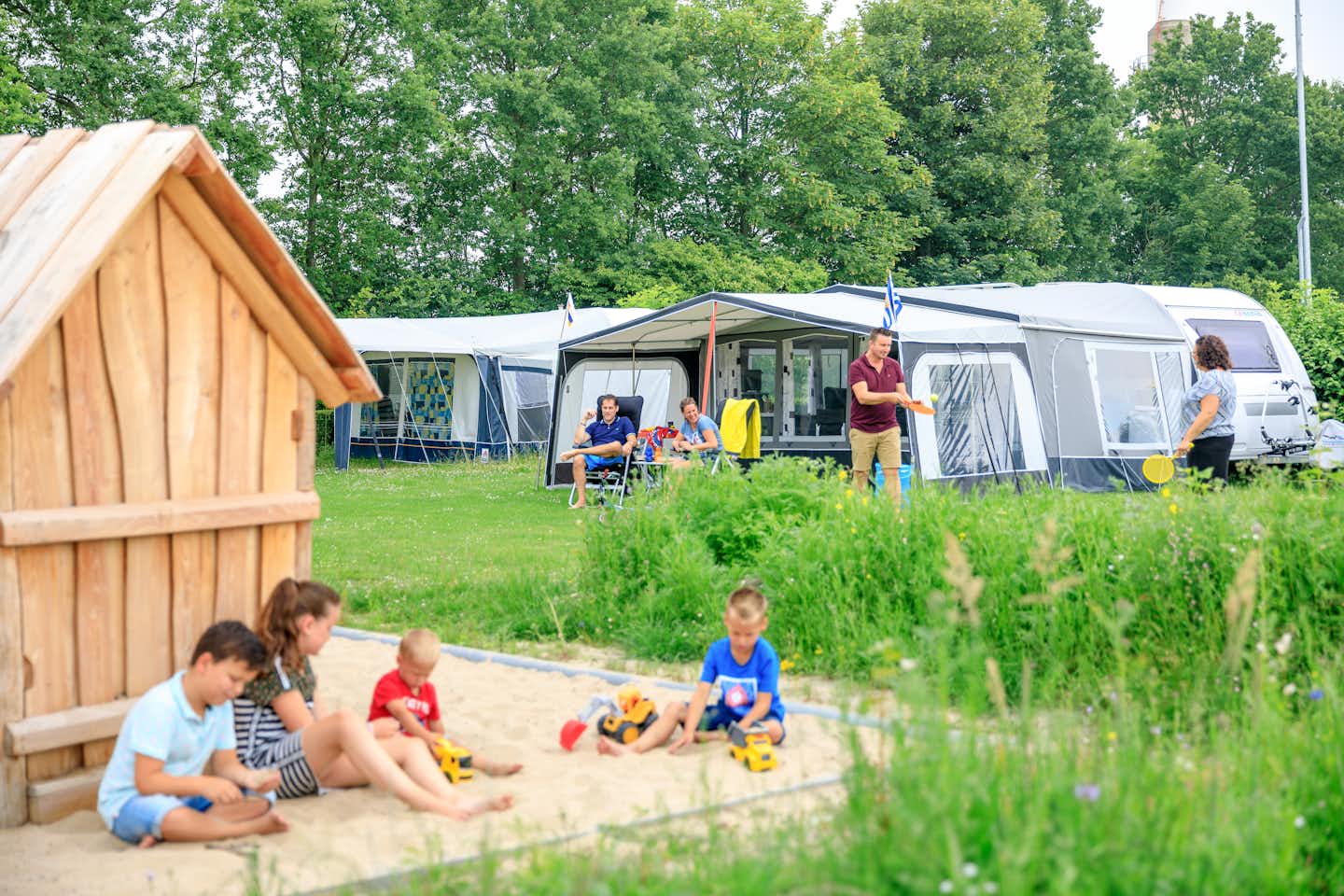 Ardoer Comfortcamping Scheldeoord  - Kinder im Sandkasten auf dem vom Campingplatz auf grüner Wiese