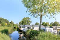 Ardoer Vakantiepark De Paardekreek - Wohnwagen- und Wohnmobilstellplätze des Campingplatzes am Bachufer
