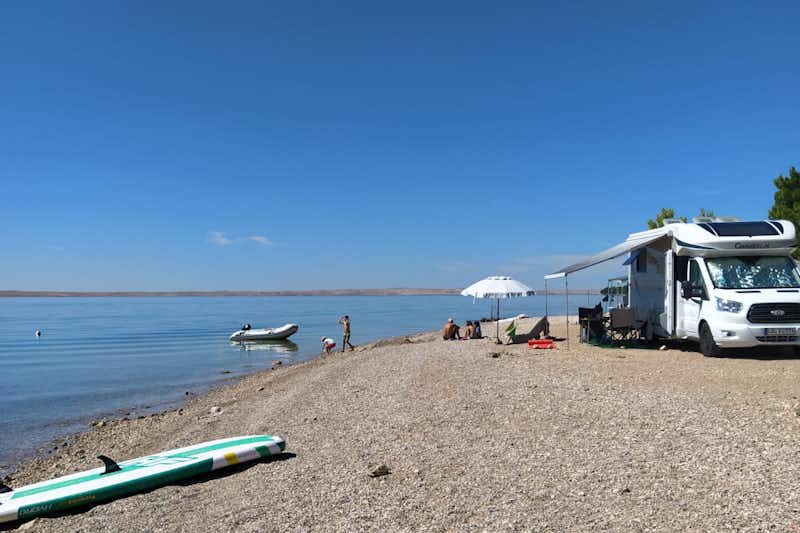 Auto Camp Navis - Strand mit geparktem Wohnmobil und Badegästen