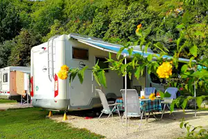 Autocamp Draga - Ein Wohnmobil mit Vorzelt und Sitzgelegenheiten auf einem Stellplatz