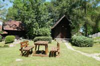 Autocamp Korana - Gartentisch auf grüner Wiese am Mobilheim auf dem Campingplatz