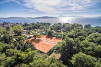 Autocamp Miran - Tennisplätze auf dem Campingplatz mit der Bucht des Mittelmeeres im Hintergrund