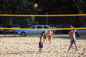 Autocamping Margita-Ilona - spielende Kinder auf dem Volleyballfeld vom Campingplatz, Parkplatz im Hintergrund