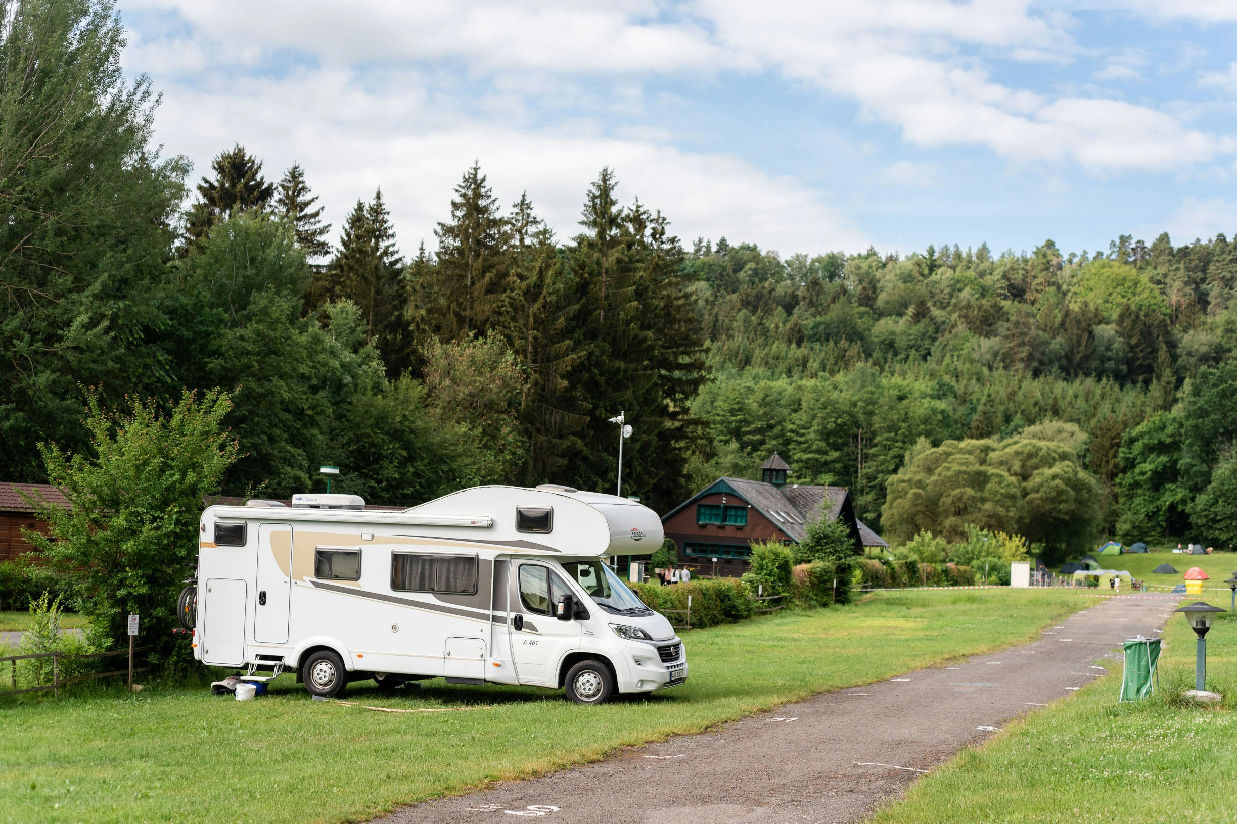 Autokamp Sedmihorky  - Standplätze mit einem Wohnmobil und umringt von Wald mit Blick auf Gebäude
