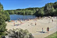 Autokamp Sedmihorky  - belebter Badestrand am See mit Volleyballfeld, der See ist umgeben von Wald