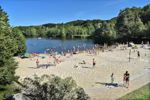 Autokamp Sedmihorky - belebter Badestrand am See mit Volleyballfeld, der See ist umgeben von Wald
