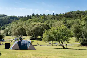 Autokamp Sedmihorky - große grüne Zeltwiese mit einigen Zelten und schattenspendenden ´Bäumen umgeben von Wald