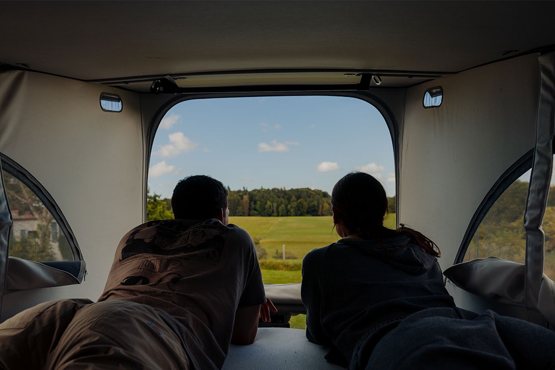 AZUR Rosencamping Schwäbische Alb - Junges Paar im Van mit der Aussicht in die Natur der Schwäbischen Alb