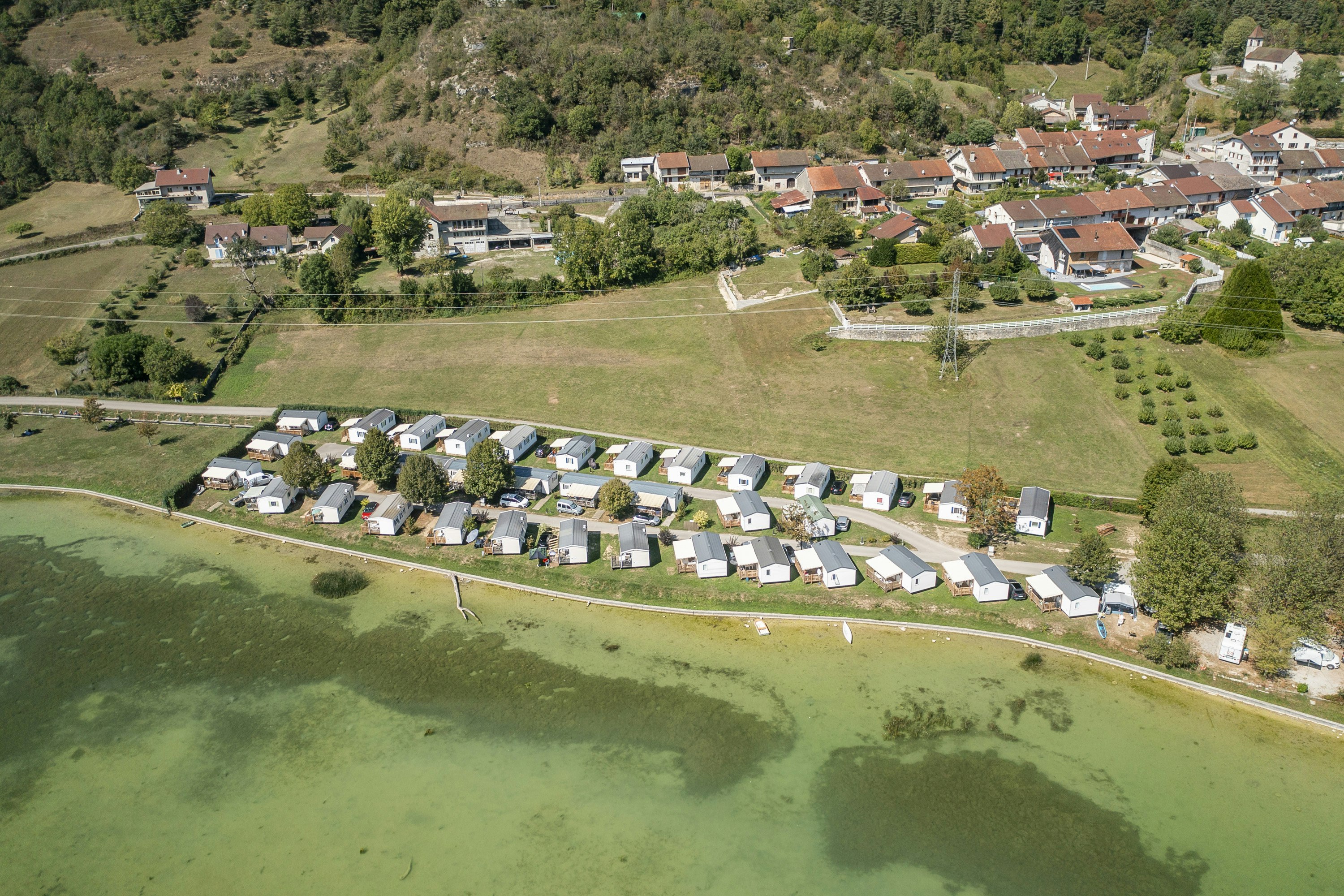 Camping Bel Air Village Sous Le Moulin  - Luftaufnahme des Campingplatzes am Wasser
