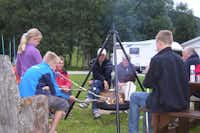 Birkelund Camping - Gäste grillen auf dem Campingplatz an der Feuerstelle.
