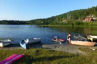 Bjønndalen Camp - Kinder spielen am Ufer des Sees zwischen Booten und Kanus