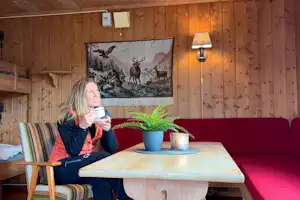 Bjørkestølen Helårscamping - Camperin genießt Kaffee im Wohnzimmer eines Mobilheims