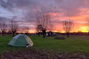 Boerderijcamping Hoeve de Mertel - Sonnenuntergang über der Zeltwiese des Campingplatzes