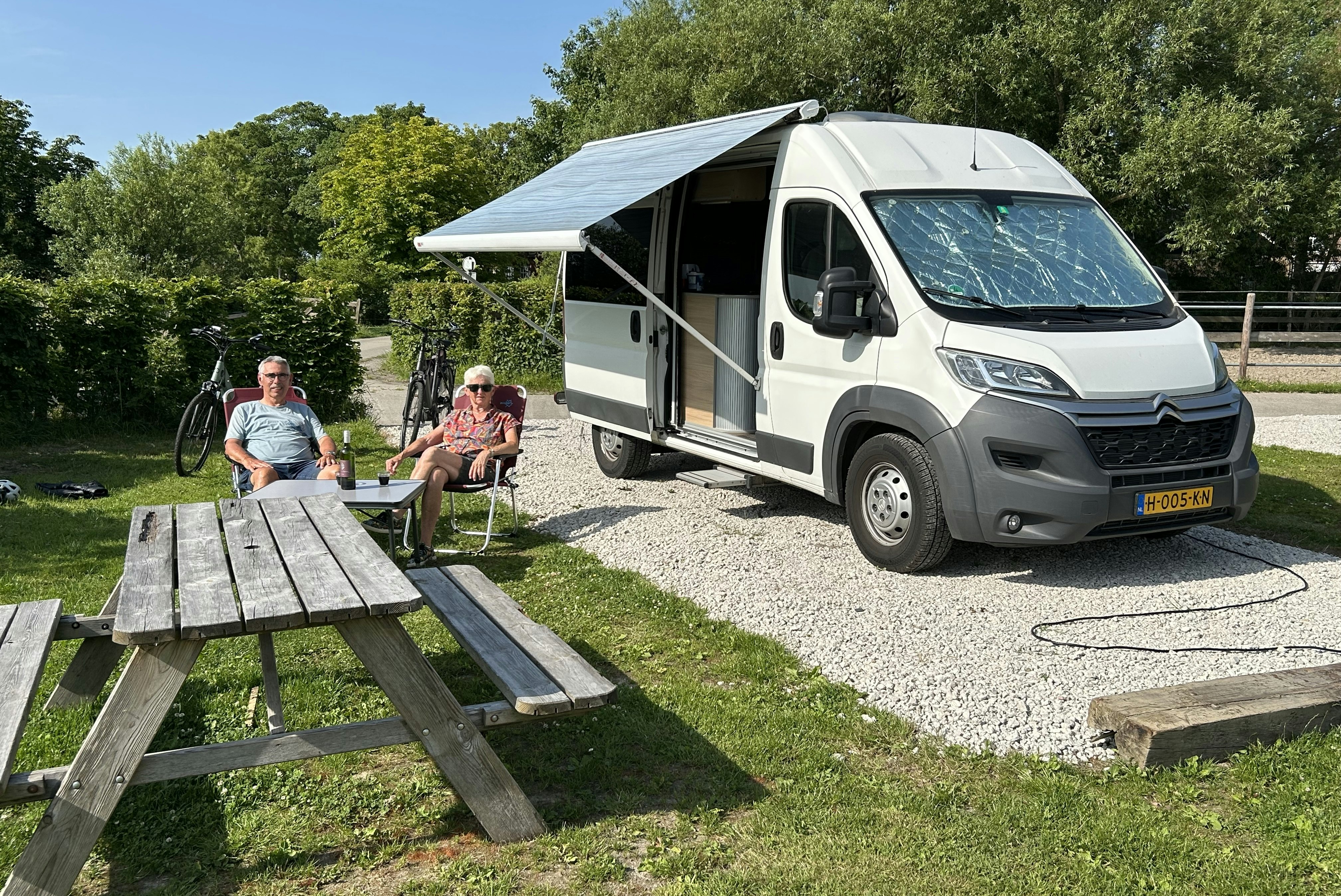 Boerencamping Ny Herema - Camper sitzen vor ihrem Van auf einem Standplatz