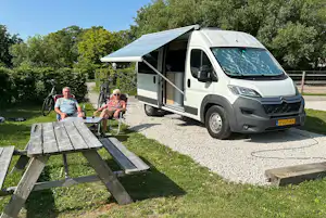 Boerencamping Ny Herema - Camper sitzen vor ihrem Van auf einem Standplatz