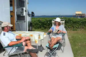 Broager Strand Camping - Camper auf dem Wohnwagen- und Zeltstellplatz mit Blick auf die Ostsee, Spielplatz vom Campingplatz im Hintergrund