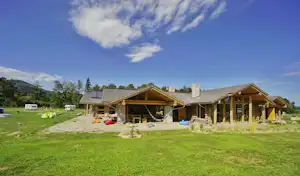 Camp 66 - Zentralhaus des Campingplatzes mit Stellplätzen im Hintergrund