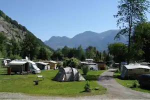 Camp Au - Wohnwagen- und Zeltstellplatz zwischen Bäumen mit den Alpen im Hintergrund