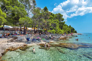 Camp Baško Polje - Blick auf den Badestrand mit Felsstrand und klarem Wasser