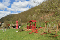 Camp BUK - Kinderspielplatz mit Wippen, Schaukeln und Holzgebäuden