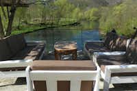 Camp BUK - Terrasse mit Sitzgelegenheiten mit Blick auf den Fluss