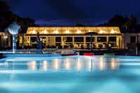Camp Hverringe - Der Swimmingpool des Campignplatzes bei Nacht mit beleuchtetem Gebäude im Hintergrund